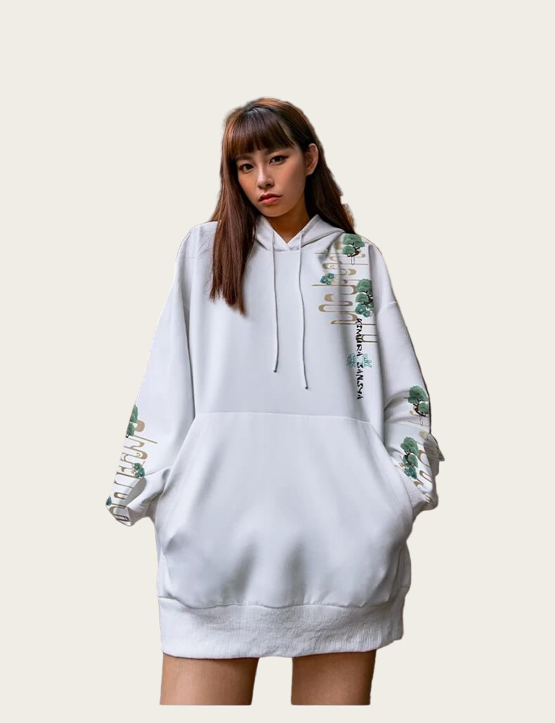 Person wearing a white hoodie and skirt with floral designs indoors.