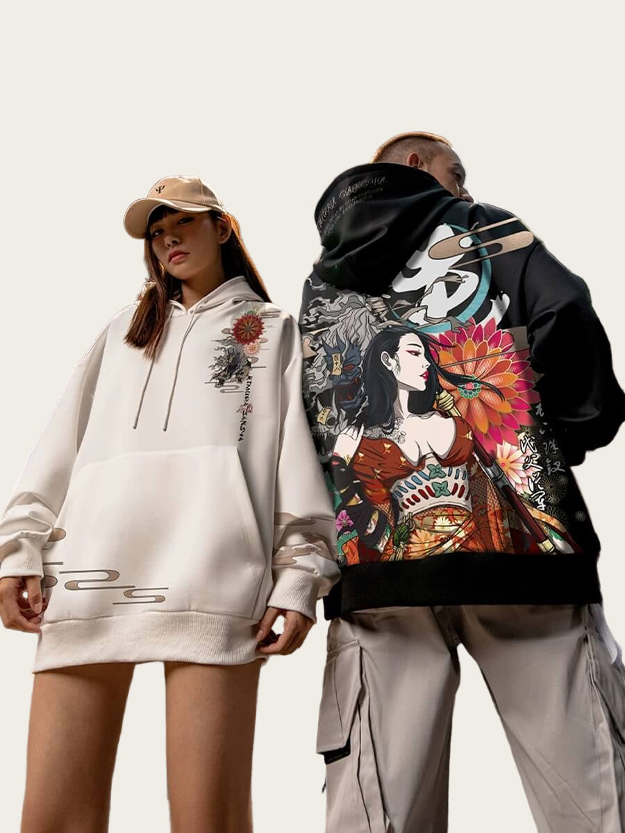 Two people wearing hoodies with artistic designs in an industrial setting