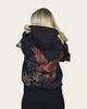 Person wearing a black hoodie with a colorful eagle design on the back against a plain background