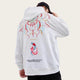 Person wearing a white hoodie with colorful designs in front of a red and white architectural background