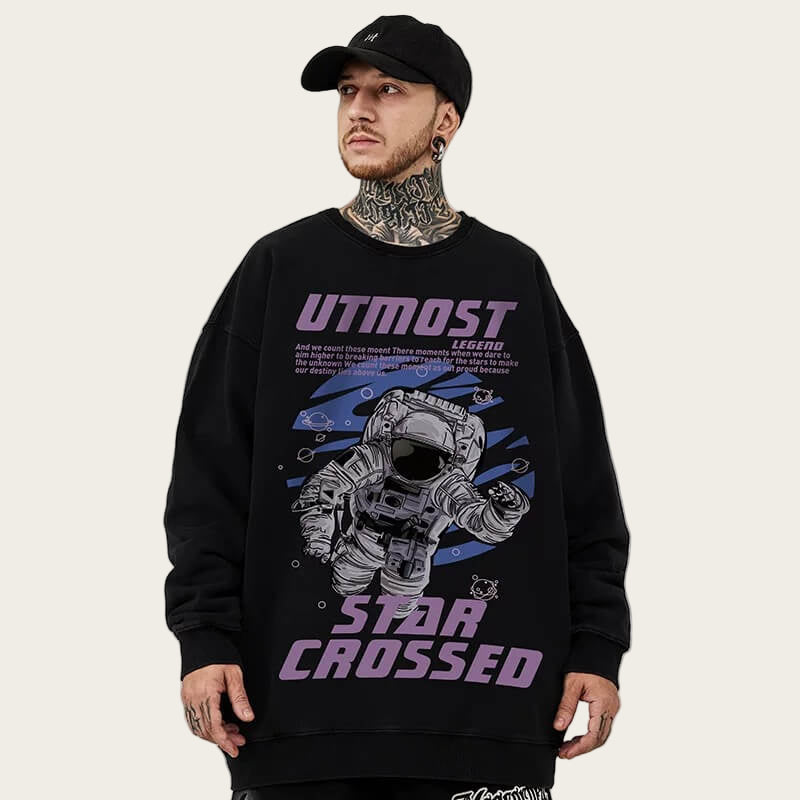 Person wearing a black sweatshirt with an astronaut graphic and 'UTMOST' text on a gray background