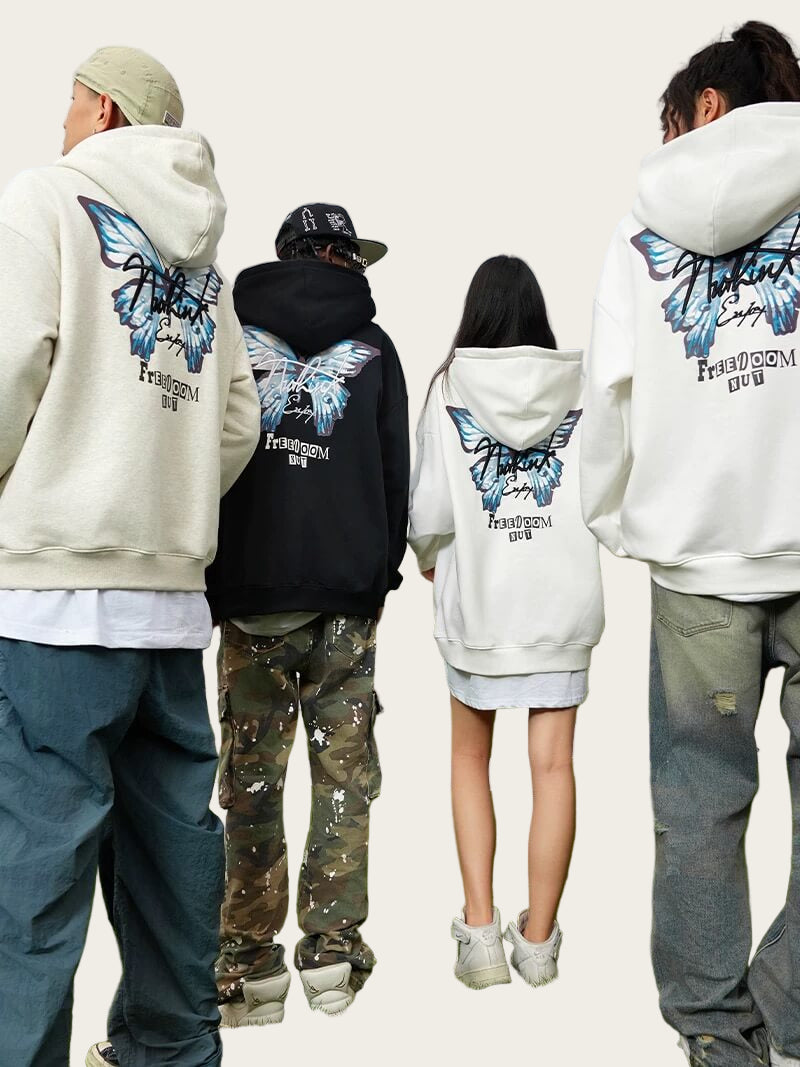 Four people wearing hoodies with butterfly designs on the back, standing outdoors.