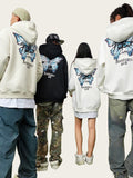 Four people wearing hoodies with butterfly designs on the back, standing outdoors.
