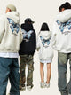 Four people wearing hoodies with butterfly designs on the back, standing outdoors.