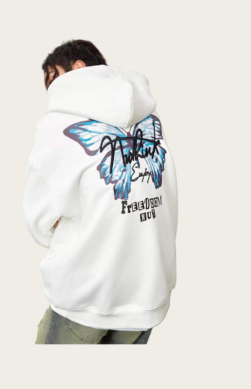 Person wearing a white hoodie with a butterfly design on the back, standing in an outdoor setting.
