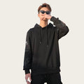 Man wearing a black hoodie and sunglasses in front of a coffee shop.