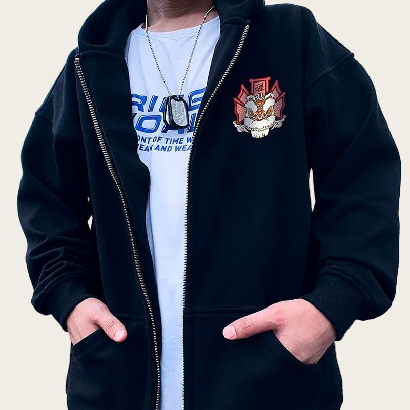 Person wearing a black hoodie with a logo and a white t-shirt with text.