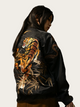 Black leather jacket with a tiger design on the back, worn by a person.