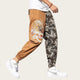Person wearing tan jogger pants with a tiger design and patterned pants on a yellow background