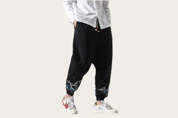 Person wearing black pants with colorful designs and white sneakers