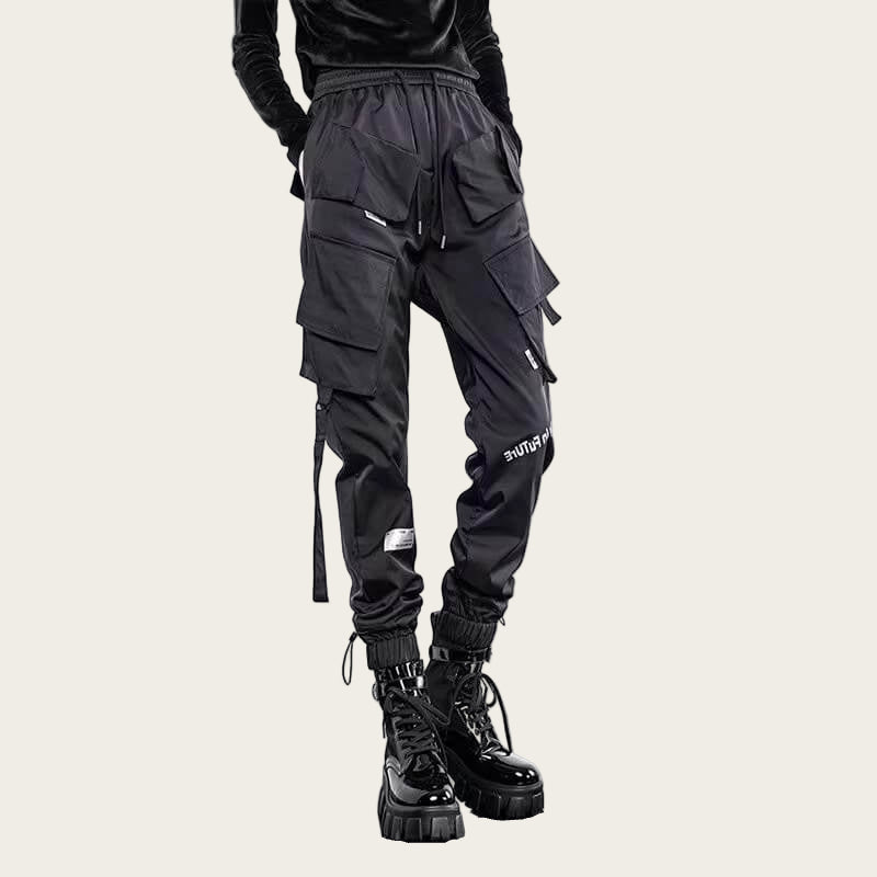 Black cargo pants with multiple pockets and zippers on a yellow background