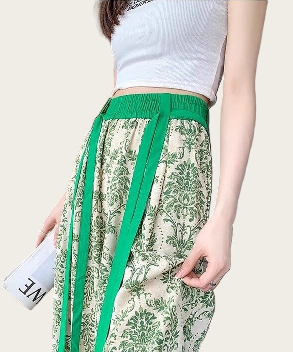 Person wearing a white top and green and beige patterned pants