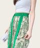 Person wearing a white top and green and beige patterned pants
