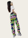 Person wearing colorful graphic pants with a white shirt, standing in front of a mirror.