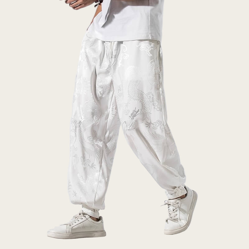 White pants with floral embroidery worn by a person on a yellow background