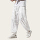 White pants with floral embroidery worn by a person on a yellow background