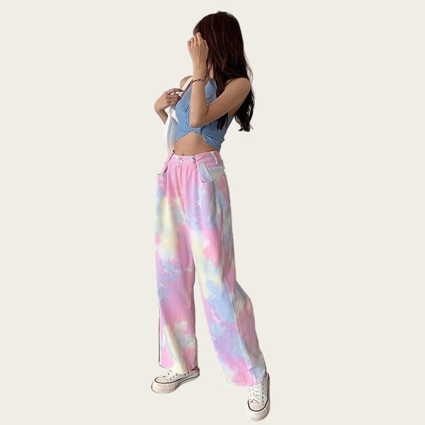 Person wearing a blue crop top and colorful tie-dye pants