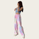 Person wearing a blue crop top and colorful tie-dye pants