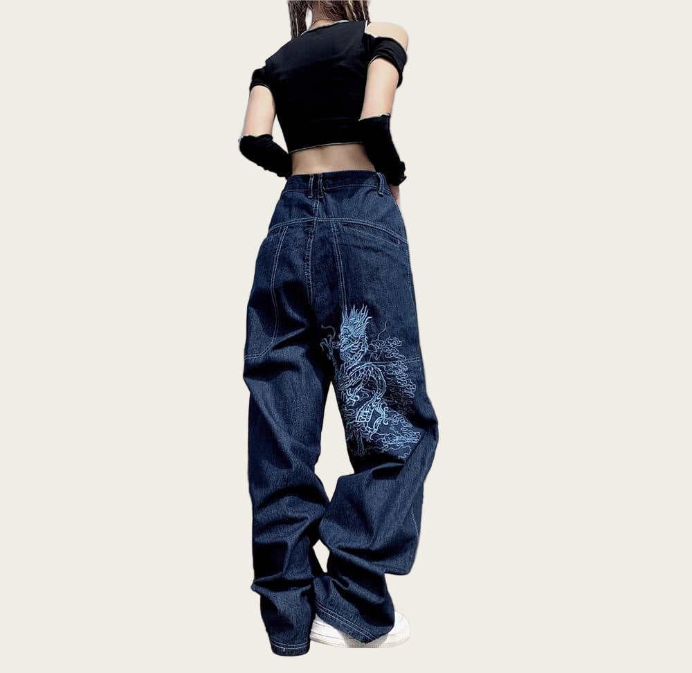 Person wearing blue jeans with a white design.
