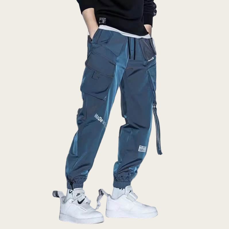 Person wearing blue cargo pants with white sneakers on a yellow background