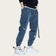 Person wearing blue cargo pants with white sneakers on a yellow background