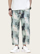 Person wearing pants with cat pattern and Chinese characters on a plain background