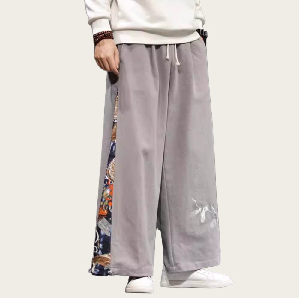 Person wearing gray wide-leg pants with colorful patterns