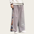 Person wearing gray wide-leg pants with colorful patterns