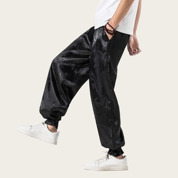Person wearing black reflective pants with white sneakers on a yellow background