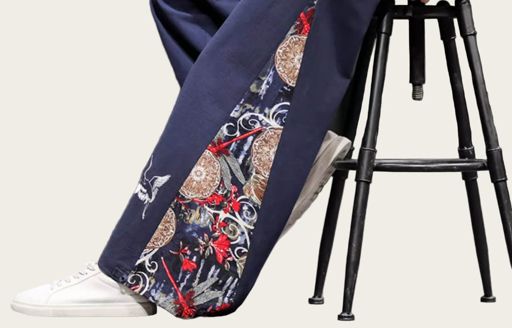 Navy blue pants with intricate patterns worn by a person, standing.