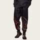 Person wearing black pants with intricate designs