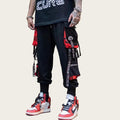 Person wearing black and red pants with visible branding, standing.