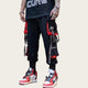 Person wearing black and red pants with visible branding, standing.