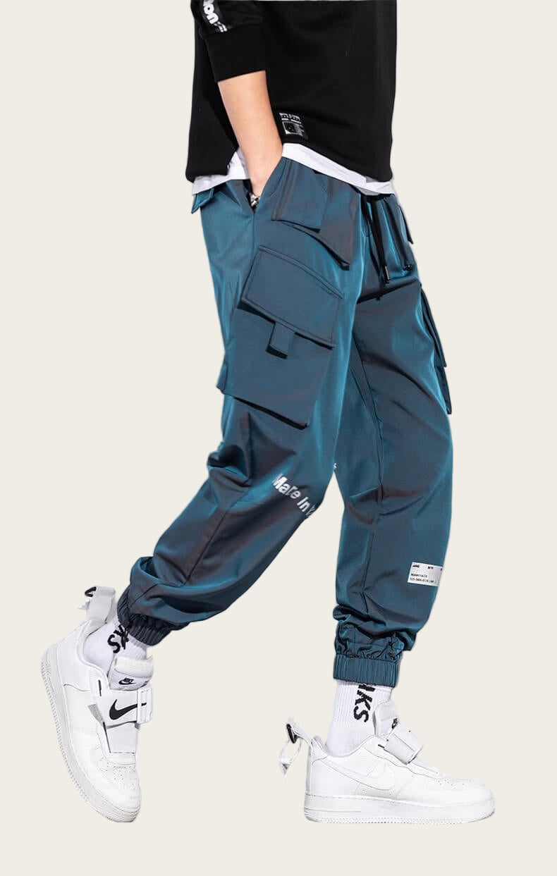 Person wearing teal cargo pants with white sneakers on a yellow background