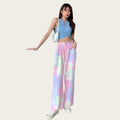 Woman wearing a blue sleeveless top and colorful tie-dye pants