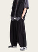 Person wearing a black outfit with a gray shirt and black shoes