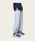 Person wearing light gray sweatpants and dark sneakers