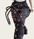 Black floral-patterned pants with a tie