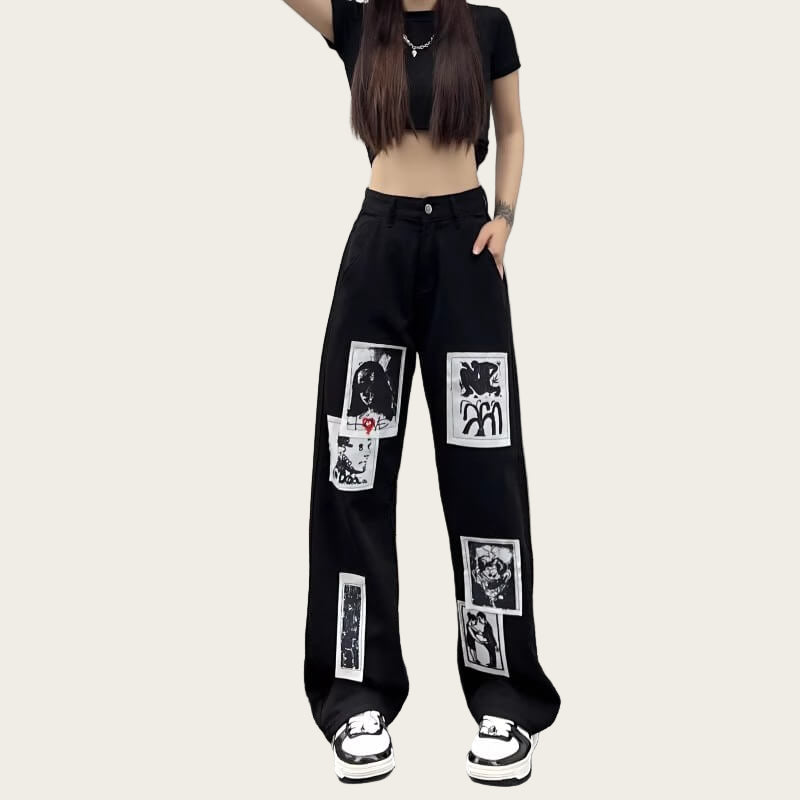 Person wearing black pants with graphic designs, standing