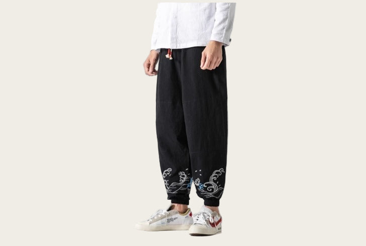 Person wearing black pants with white floral patterns on a yellow background