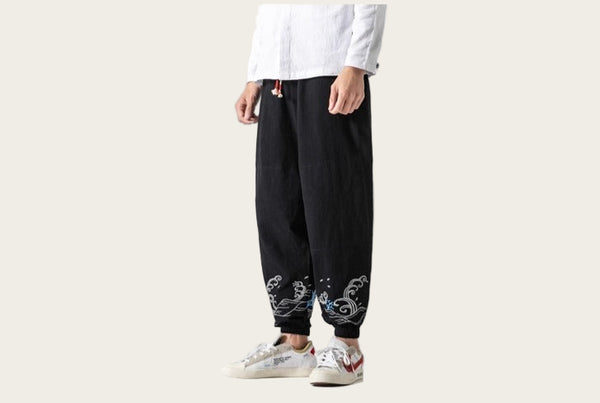 Person wearing black pants with white floral patterns on a yellow background