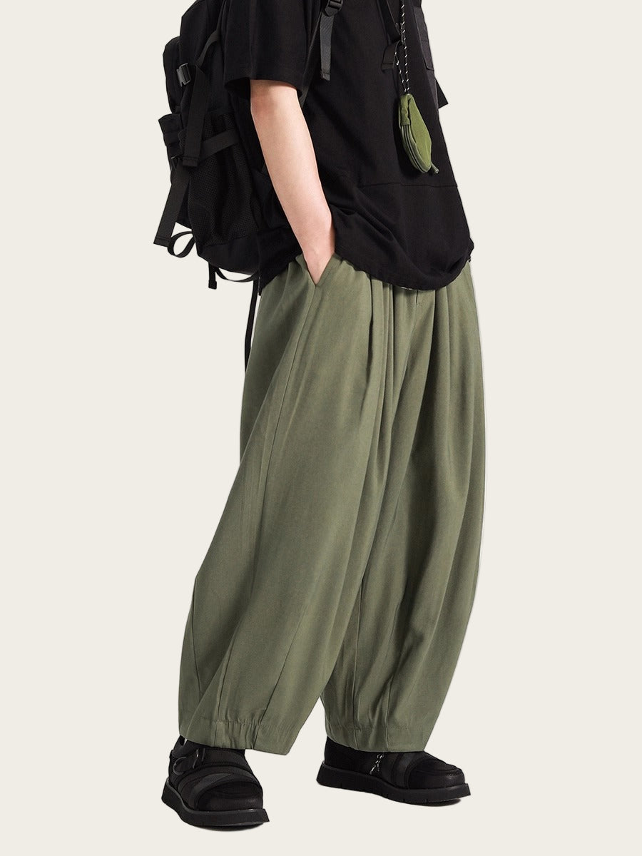 Person wearing olive green wide-leg pants with a black backpack