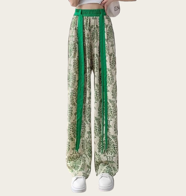 Person wearing green and white floral pants with a green waistband