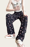 Person wearing floral pants and a white tank top
