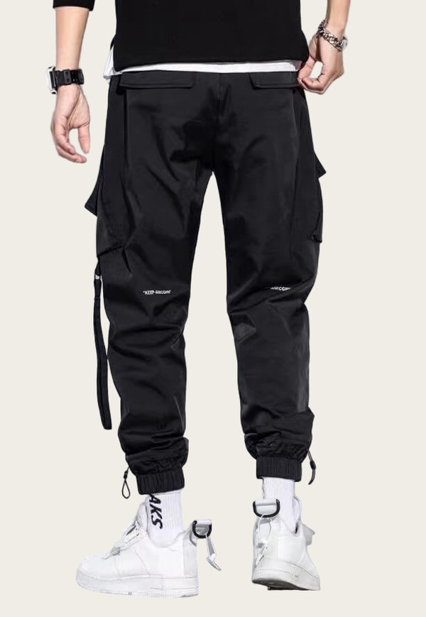 Black cargo pants worn by a person on a yellow background