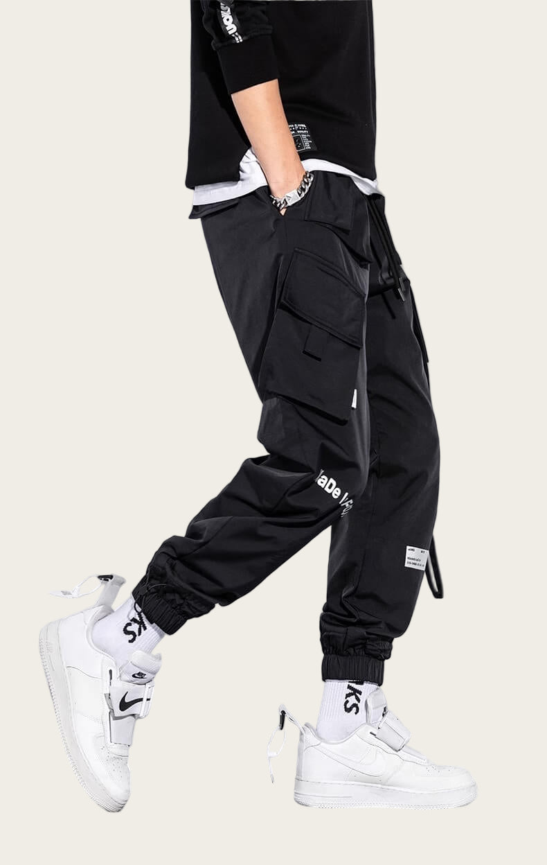 Black cargo pants with white sneakers on a yellow background
