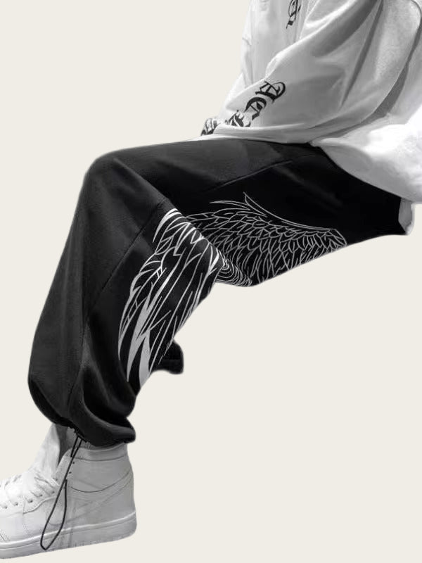 Person wearing black pants with a white design, white sneakers, and a white hoodie
