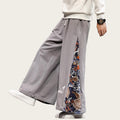 Person wearing gray wide-leg pants with floral side panels