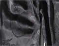 Close-up of black fabric with intricate patterns and textures