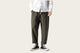 Person wearing a white shirt and green pants with black shoes